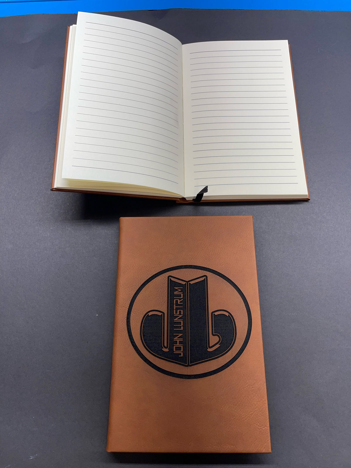 Open lined journal above an engraved rawhide leatherette journal